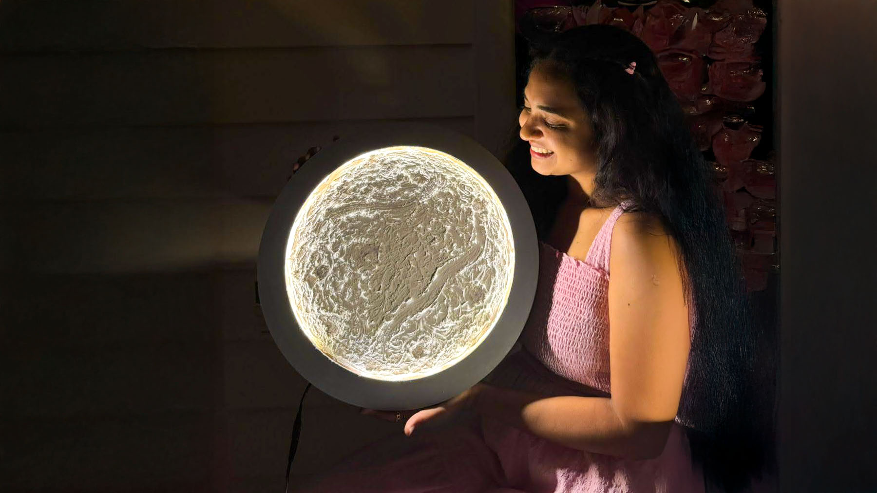Wide shot of a happy group holding their crafted glowing moon lamps after completing the project.